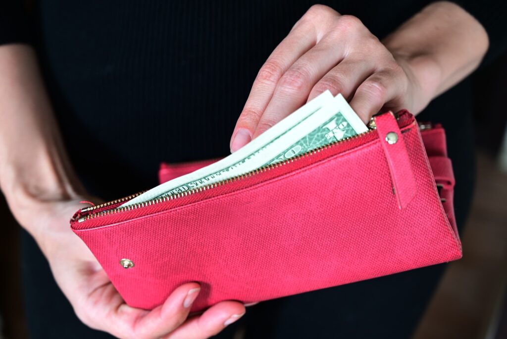 women's hands hold money, a purse with money
